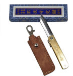 Traditional Japanese brass folding knife stored inside its custom leather sheath.
